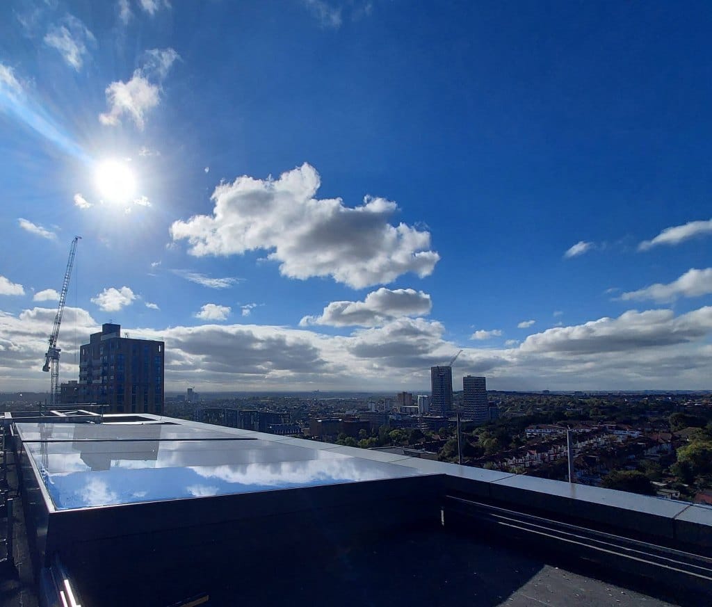rooflight installed on a high rooftop in London with a blue sky and some clouds